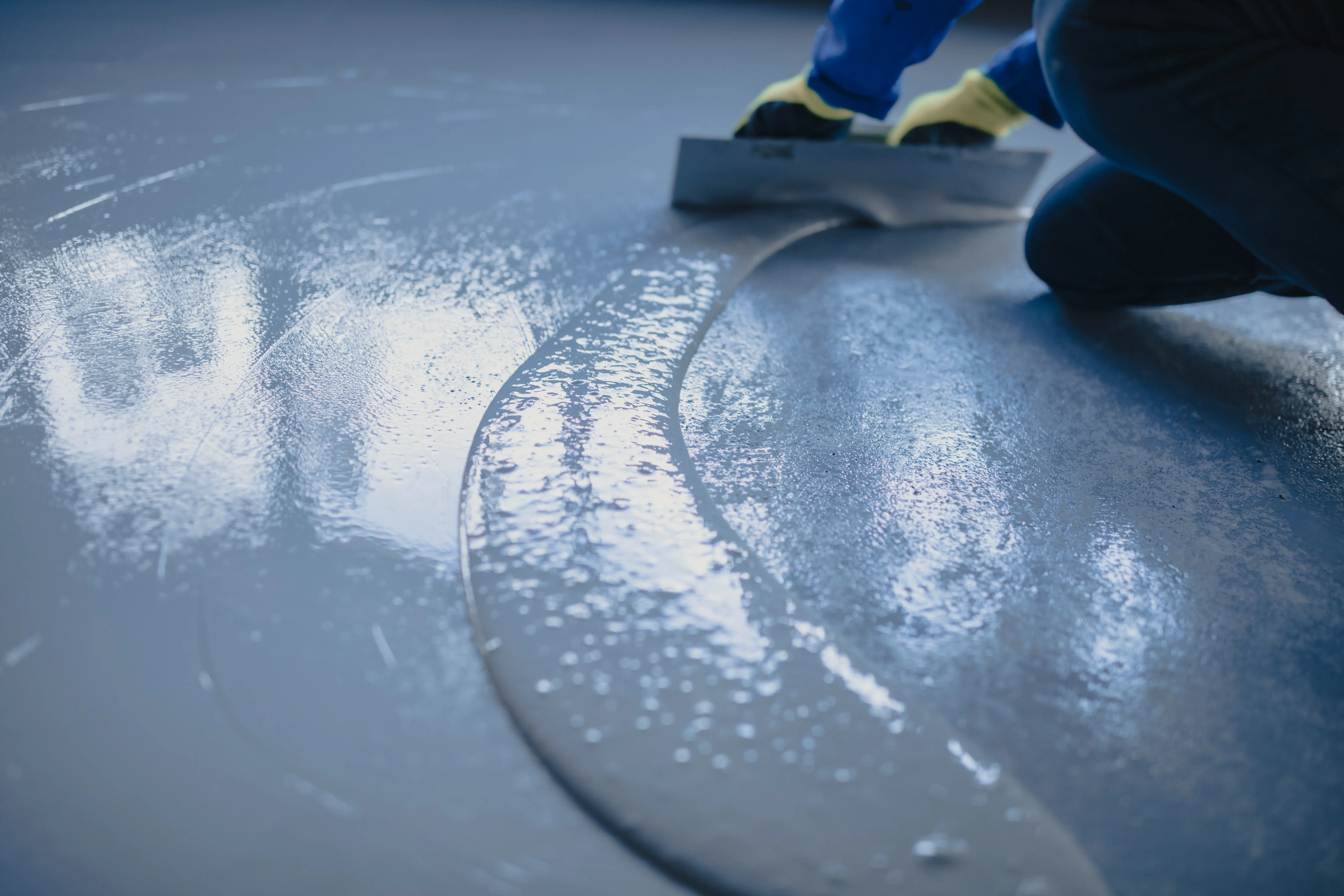 Installer applying epoxy floor coating during resurfacing project Vancouver