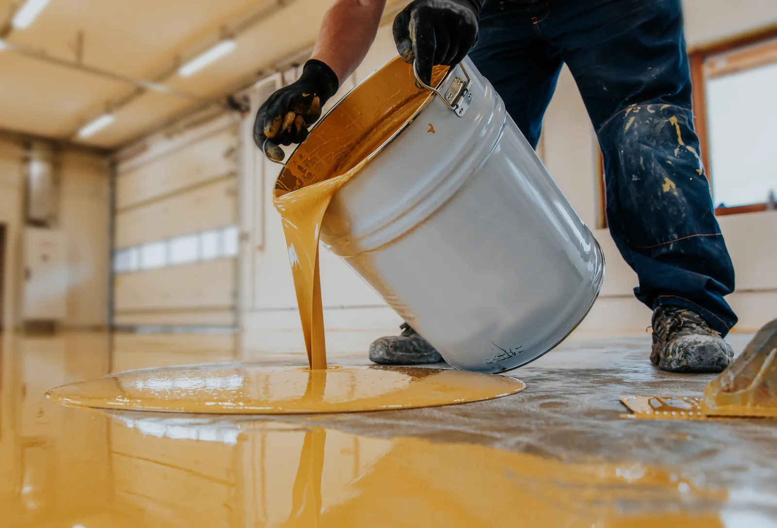 Professional installer pouring epoxy floor coating — garage floor installation Vancouver BC