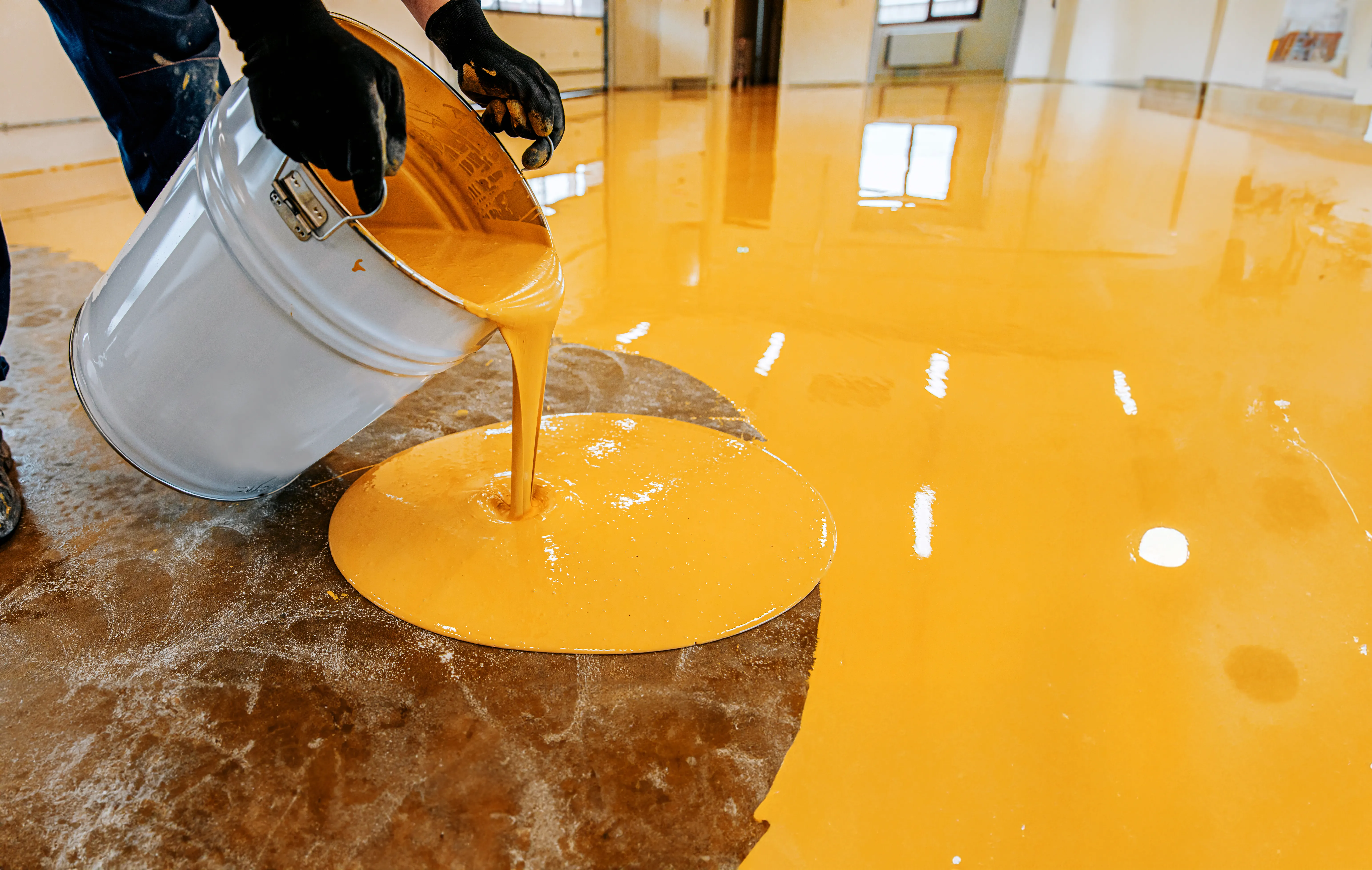 Epoxy coating being poured during floor resurfacing installation Vancouver