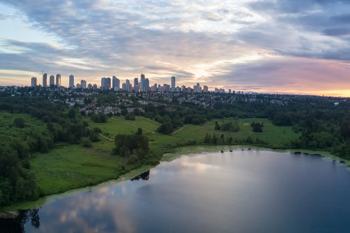Aerial view of Deer Lake Park with the Metrotown skyline in Burnaby, BC, at sunset