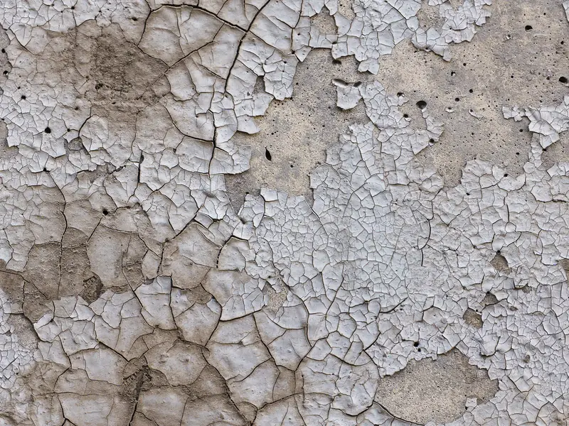 Cracked and peeling paint on a concrete garage floor — the typical failure pattern of latex and acrylic floor coatings in Vancouver BC garages